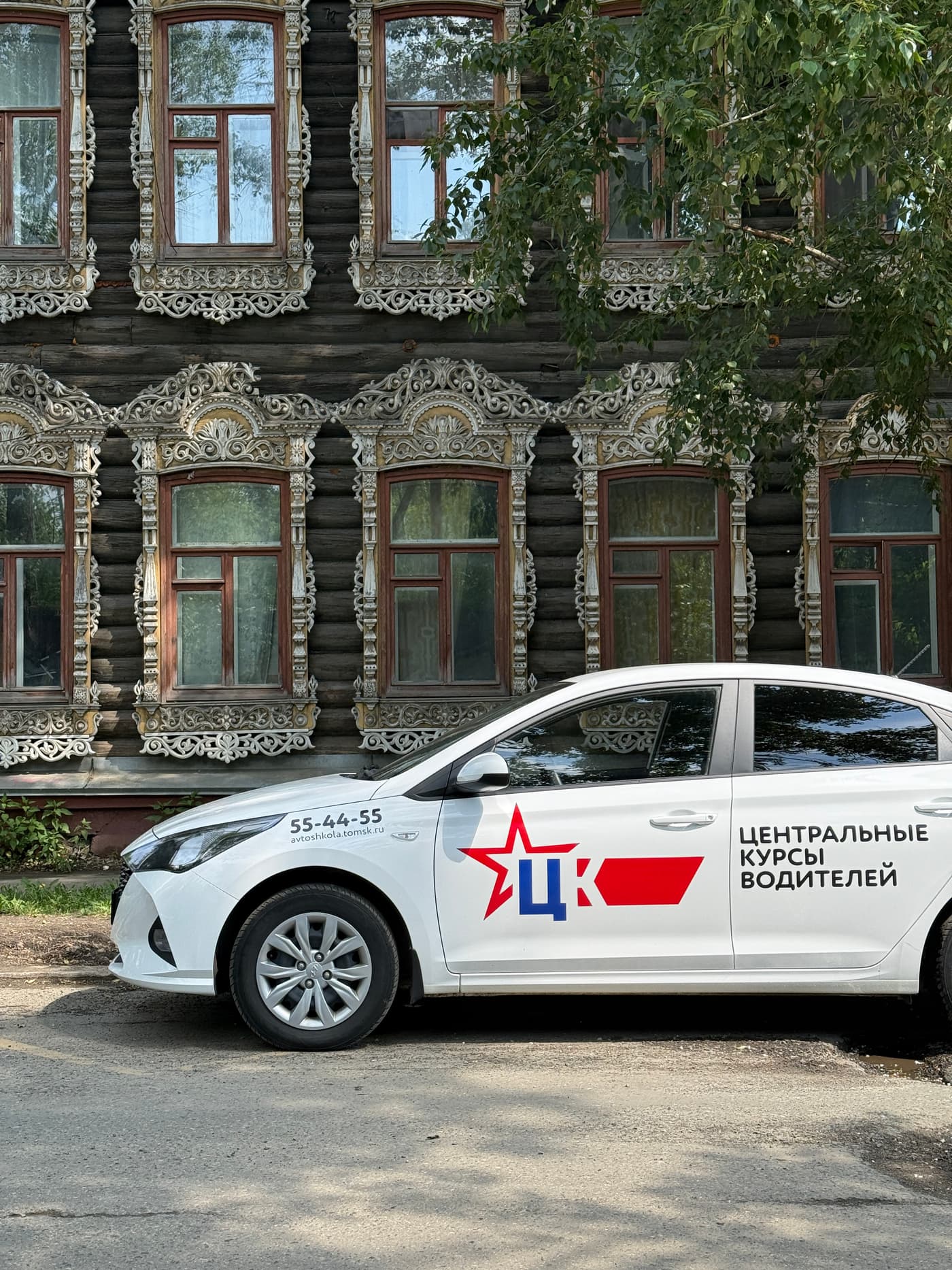 Учебный автомобиль автошколы ЦКВ на фоне исторической застройки Томска